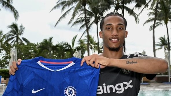 Joao Pedro holding up a Chelsea shirt
