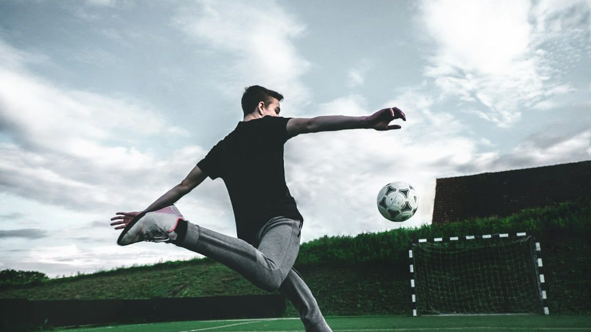 A young footballer striking a ball in training